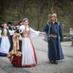 Muž a žena odetí v historických šatách počas sprievodu