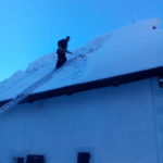 Odstraňovanie snehu z ostrechy na Vyšnokubínksje kúrii v Zuberci